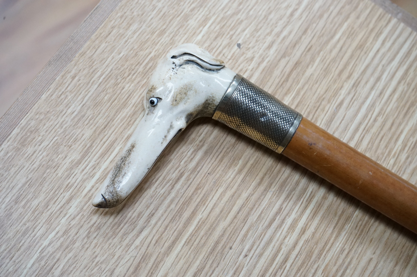A riding crop with carved stag antler dog’s head handle together with a leather cased riding flask, 79cm. Condition - fair to good